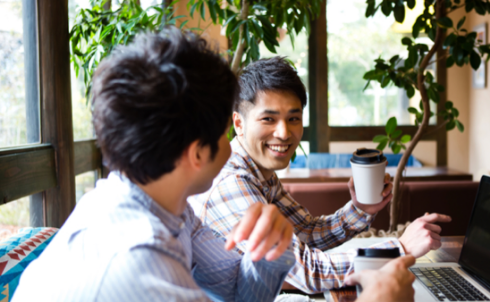 飲み物を片手に談笑する若い男性